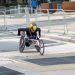 A dedicated athlete competes in a marathon using a racing wheelchair on city streets.