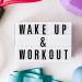 Top view closeup composition of wake up and workout inscription on light box surface among expanders and dumbbells and massage ball on white background